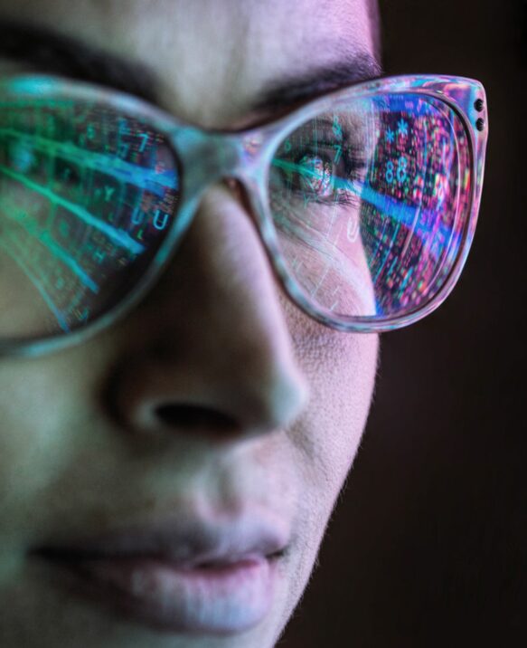 woman wearing glasses reflecting a digital screen with statistics
