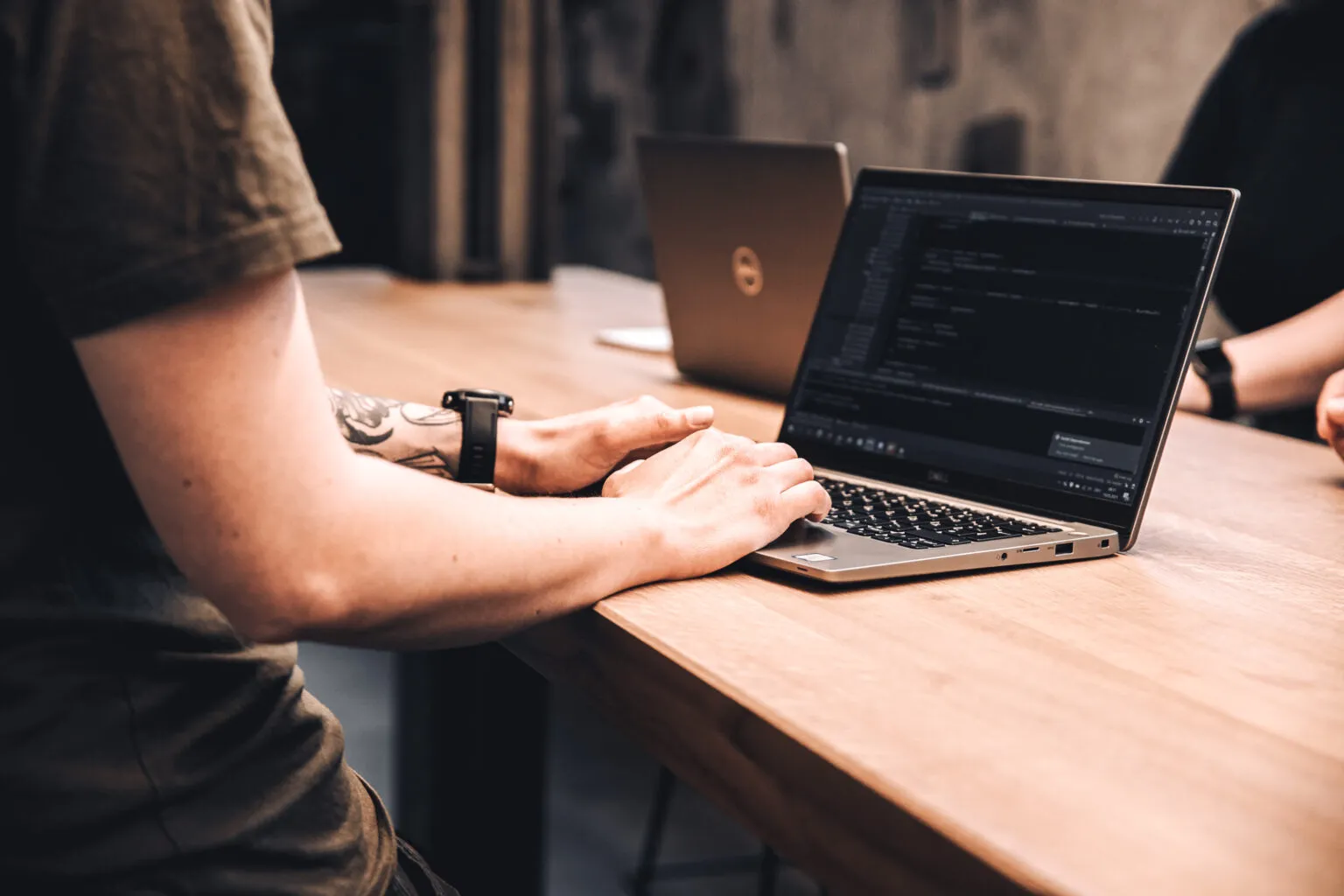 Nahaufnahme von Händen, die auf einem Laptop arbeiten.