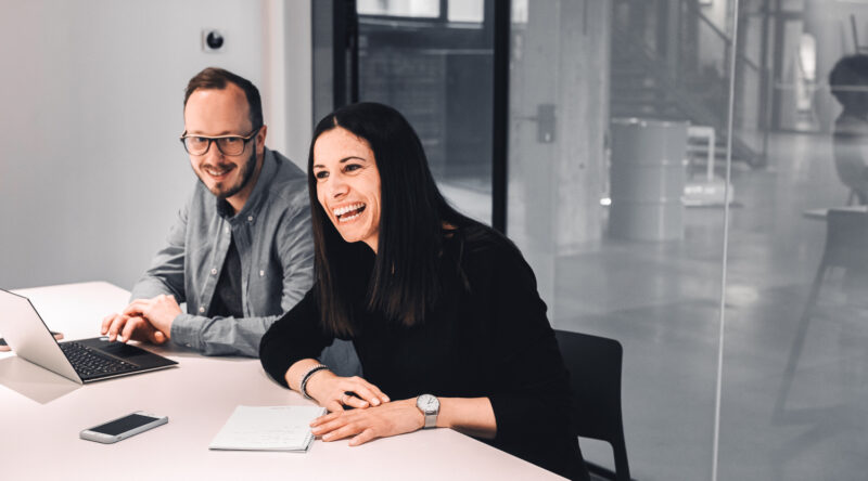 Zwei valantic Austria Mitarbeiter*innen, die zusammen in einem Meeting-Raum sitzen.