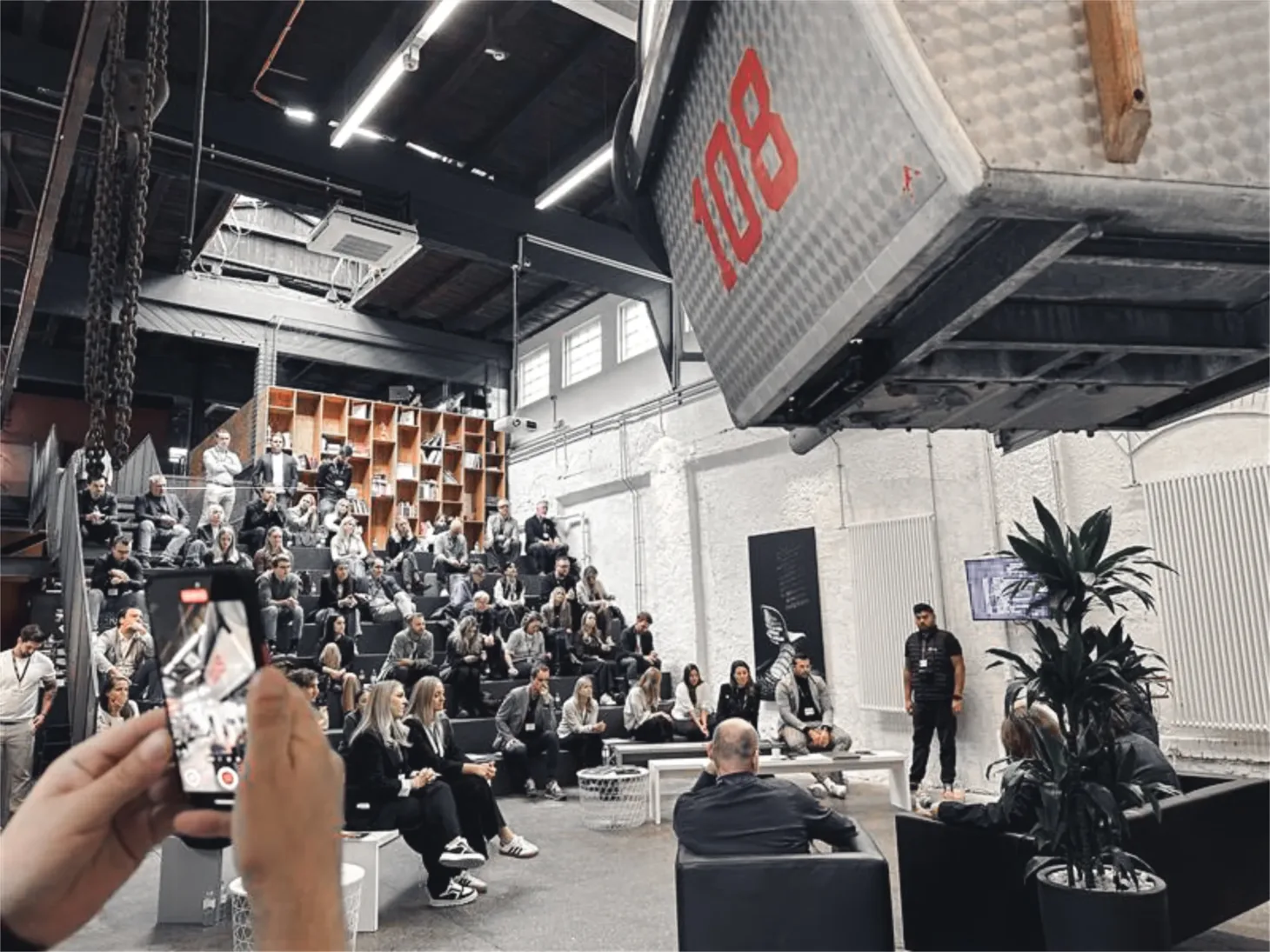 Jemand filmt mit dem Handy einen Vortrag der Digital Distillery