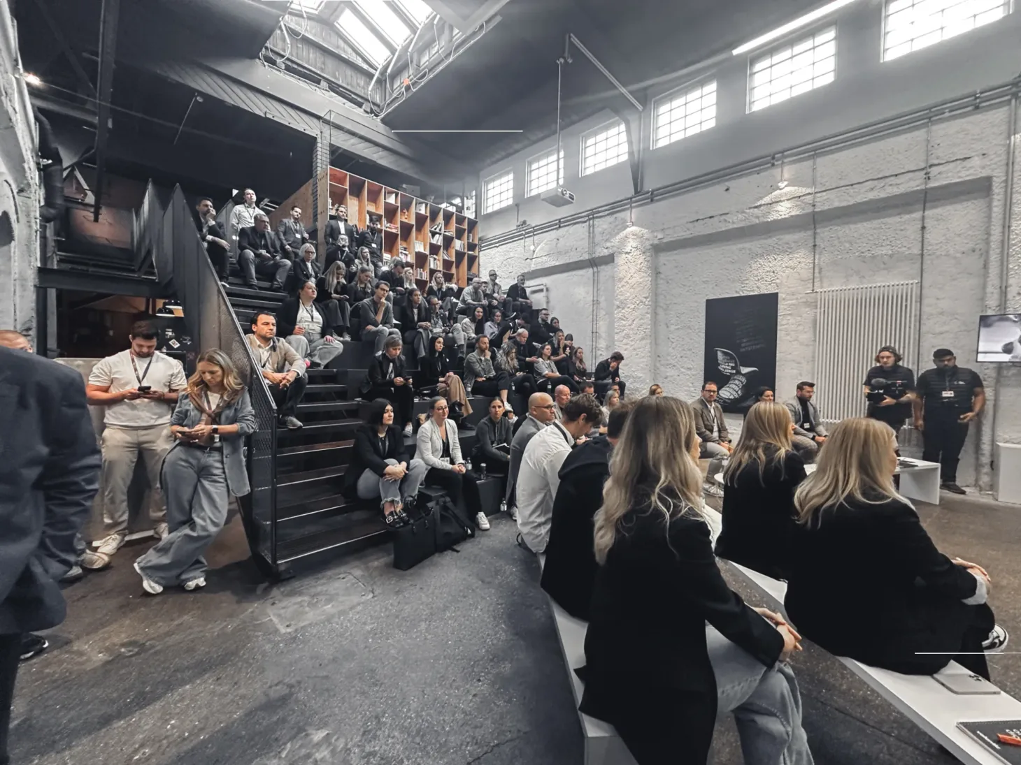 Die Teilnehmerinnen der Digital Distillery bei valantic Austria sitzen auf einer Treppe und folgen einem Vortrag.