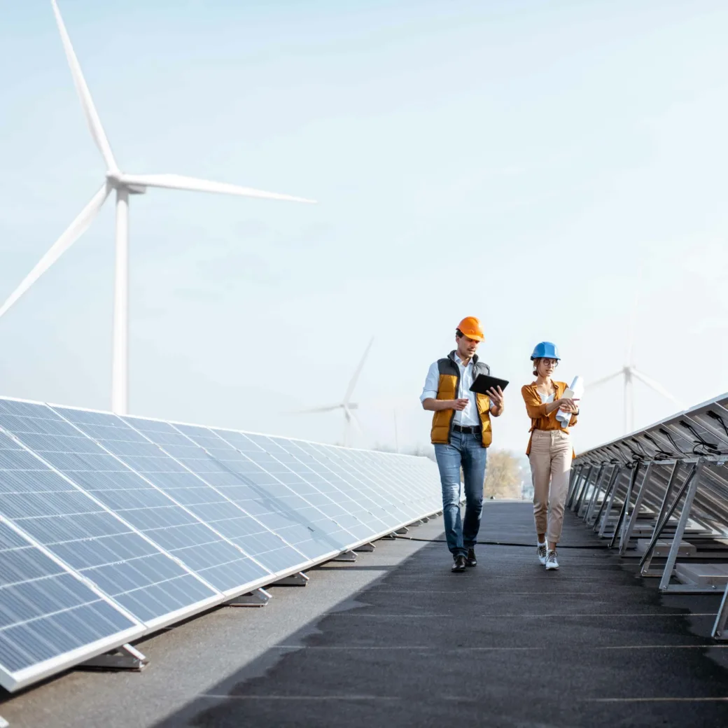 Zwei Kollegen sprechen zwischen Energieanlagen und Windmühlen für die EVU Prozess & IT Tage 2026.