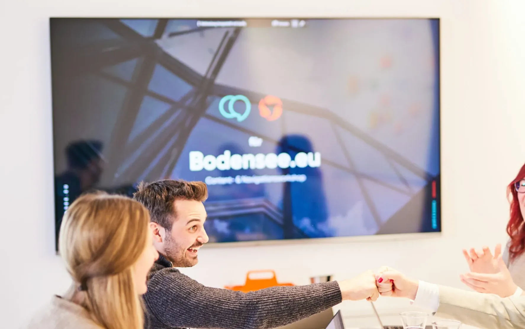 Foto von drei Kolleg*innen beim Kaffee trinken.