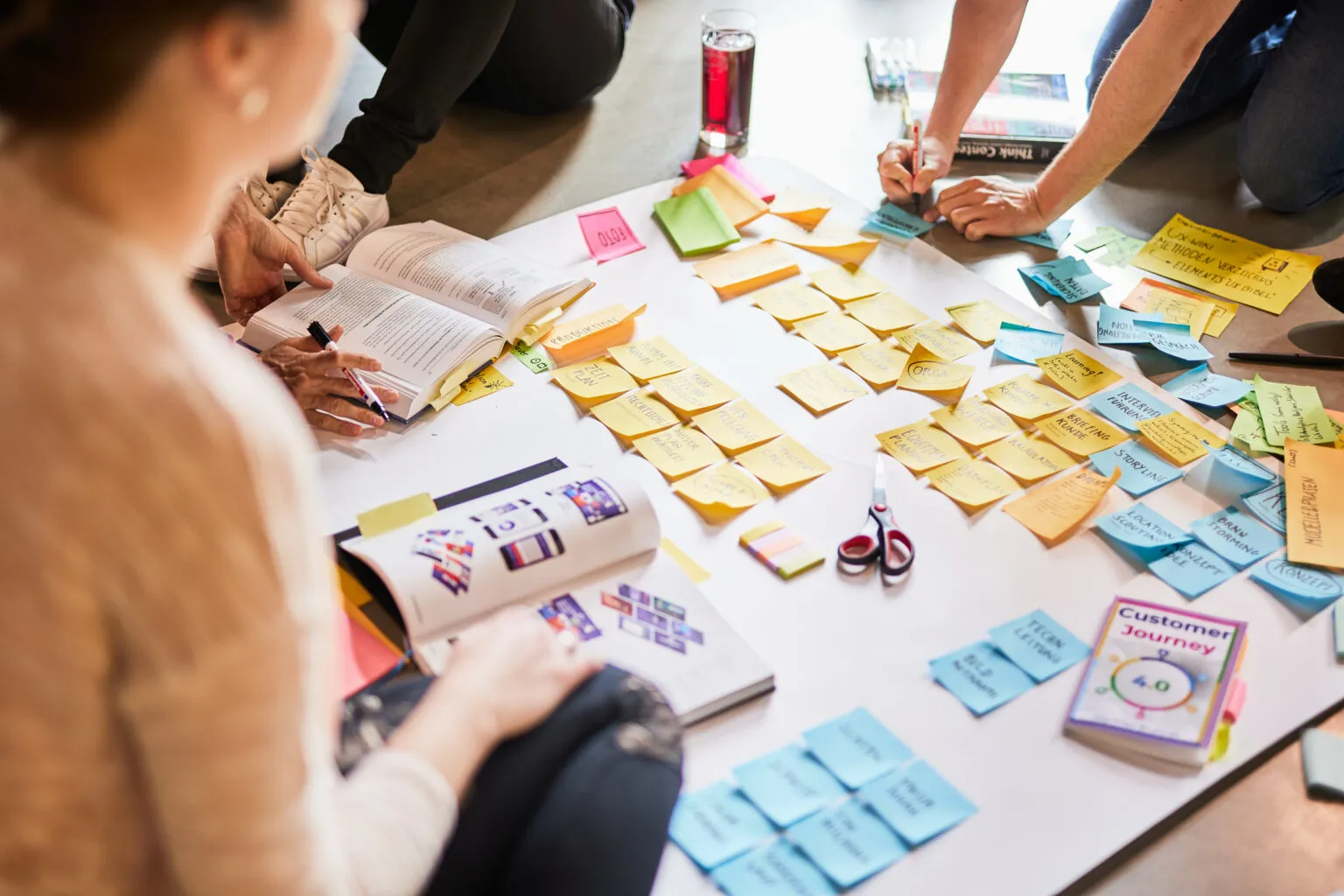 Several people are using Post-Its to design a poster for a presentation.