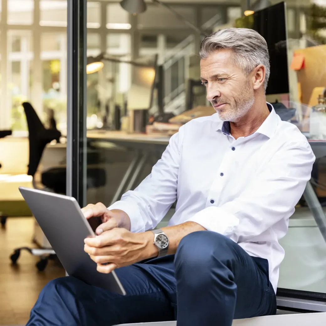 Businessman working on digital tablet while sitting in office