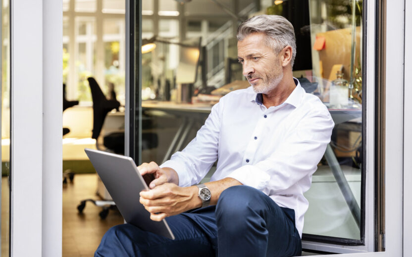 Businessman working on digital tablet while sitting in office