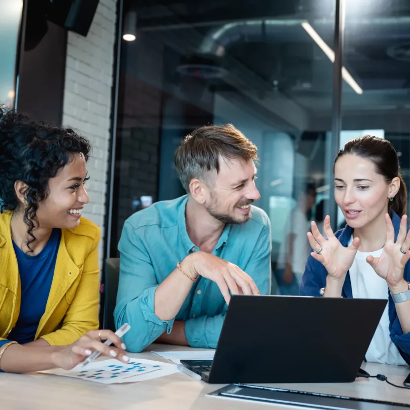 Gruppe von drei Personen diskutiert am Laptop die Ergebnisse der valantic SAP Studie 2026