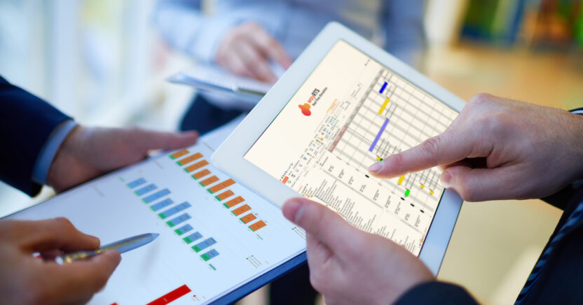 Zwei Personen überprüfen Diagramme auf einem Tablet und einem Klemmbrett und sind dabei in die Datenanalyse vertieft. Eine Person zeigt auf eine Tabelle auf dem Tablet und navigiert gekonnt durch die waySUITE-Oberfläche, um Erkenntnisse zu gewinnen.