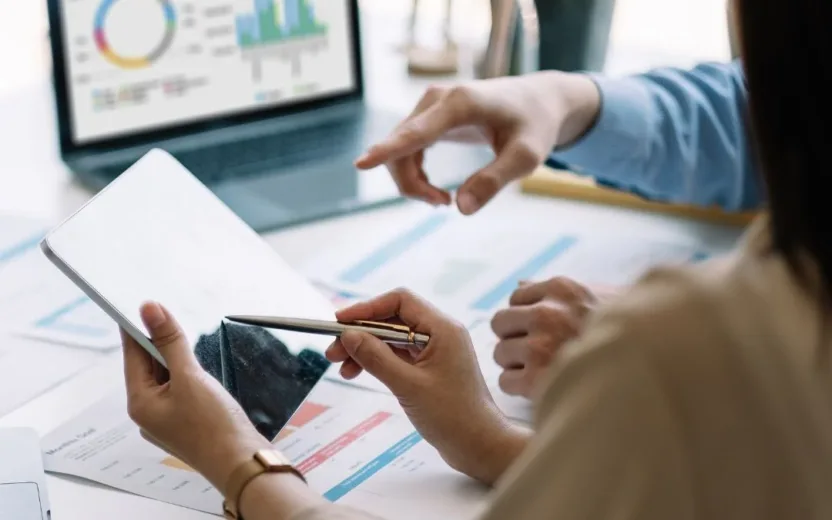 People sitting behind a desk looking at a data dashboard