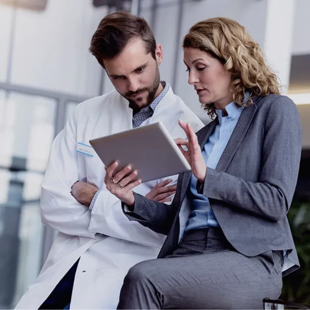 Geschäftsfrau mit Tablet im Gespräch mit Arzt