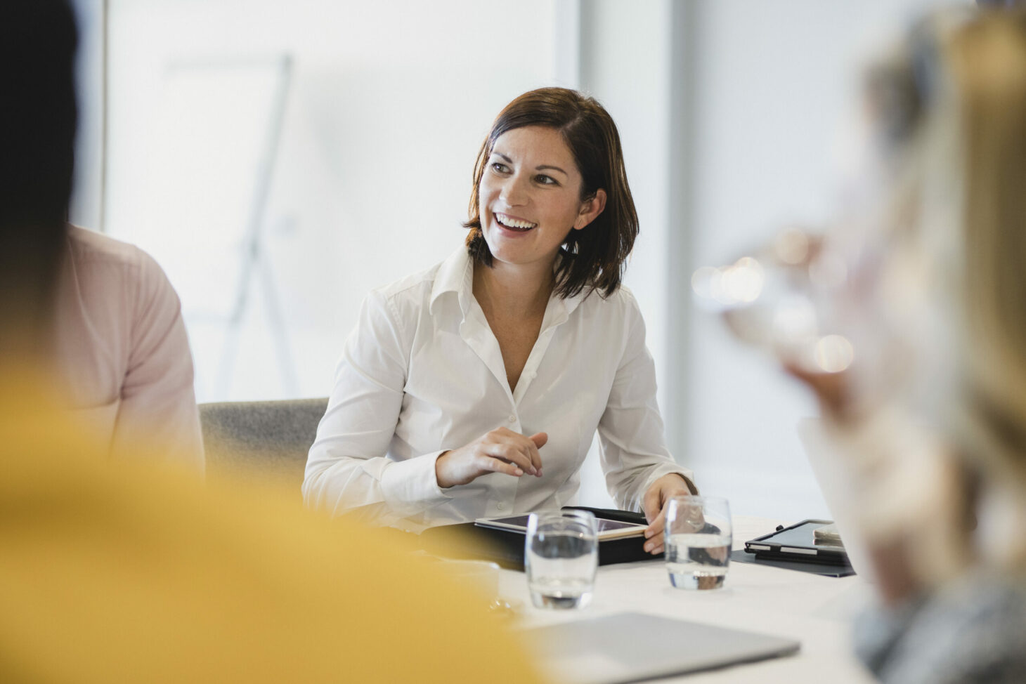 Cheerful mid adult woman smiling at business meeting