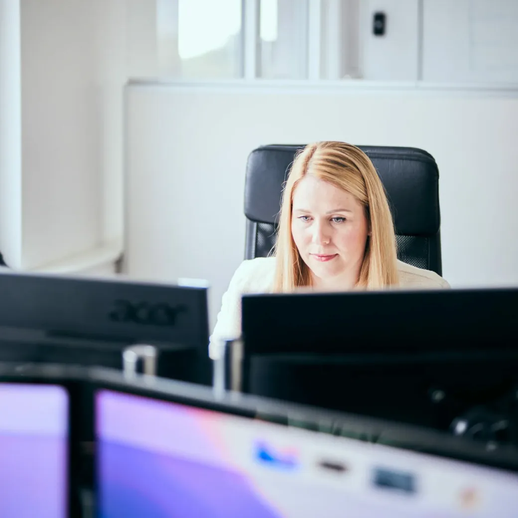 Photo of a valantic CX employee working intently on a customer experience strategy at her PC.