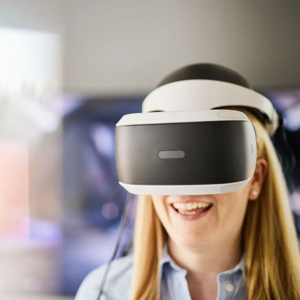 Photo of happy woman wearing VR glasses.