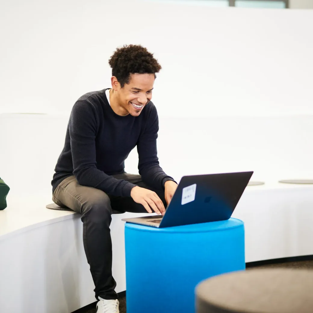A happy colleague working on the laptop.