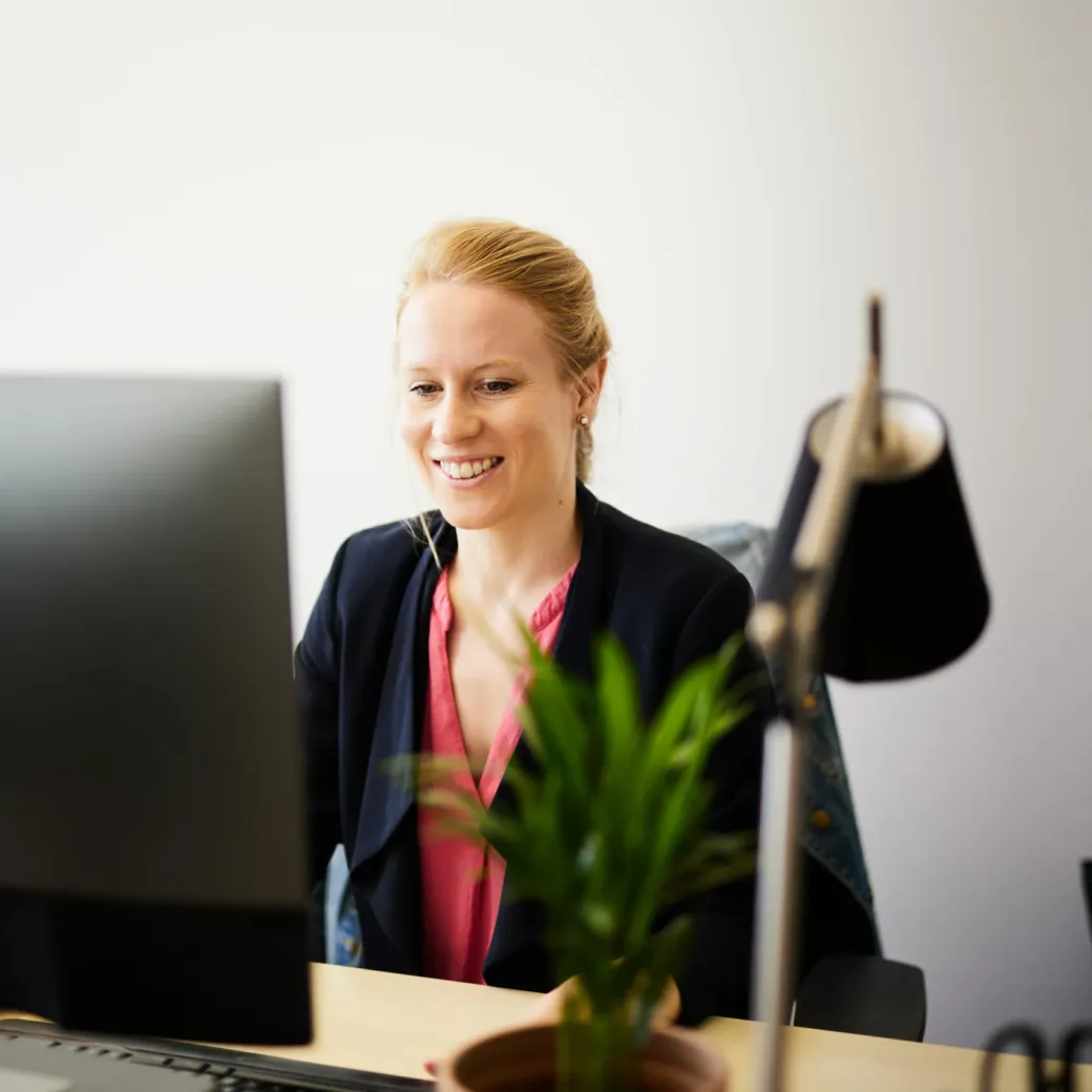 Photo of happy woman sitting and working at her office desk.