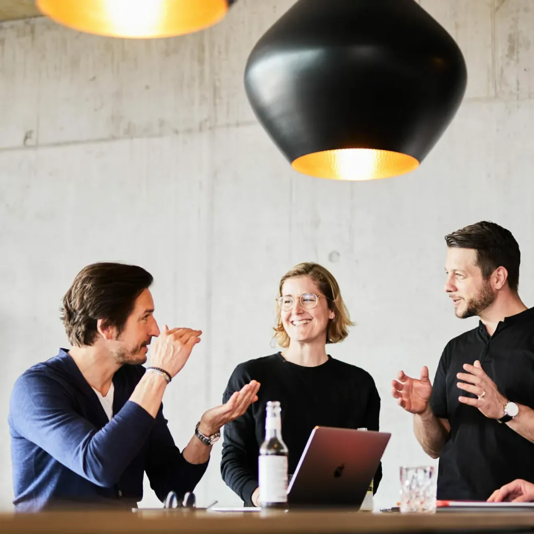 Foto von einem Teammeeting am Stehtisch.