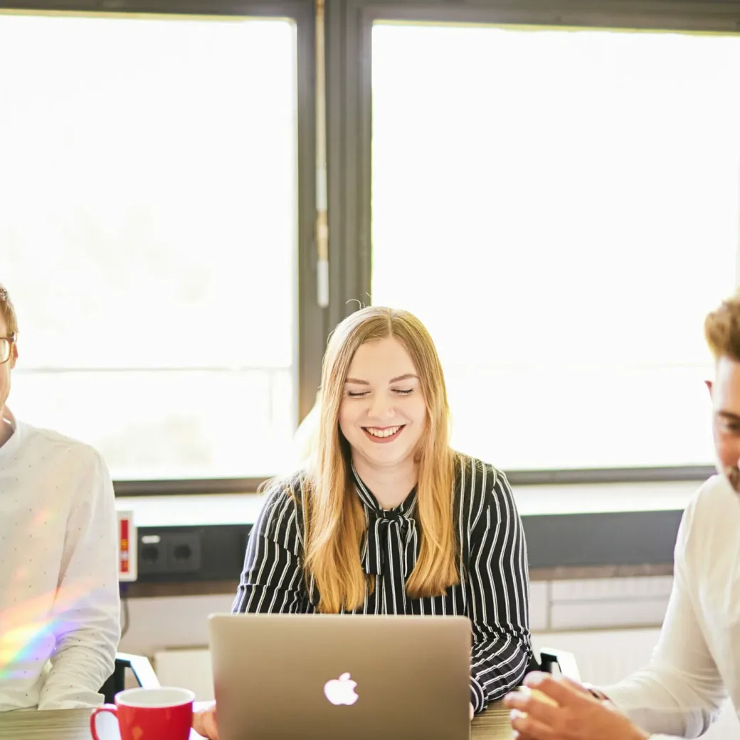 Foto von zwei glücklichen valantic-CX-Mitarbeitern, die an einer Teambesprechung zur Customer Experience teilnehmen.