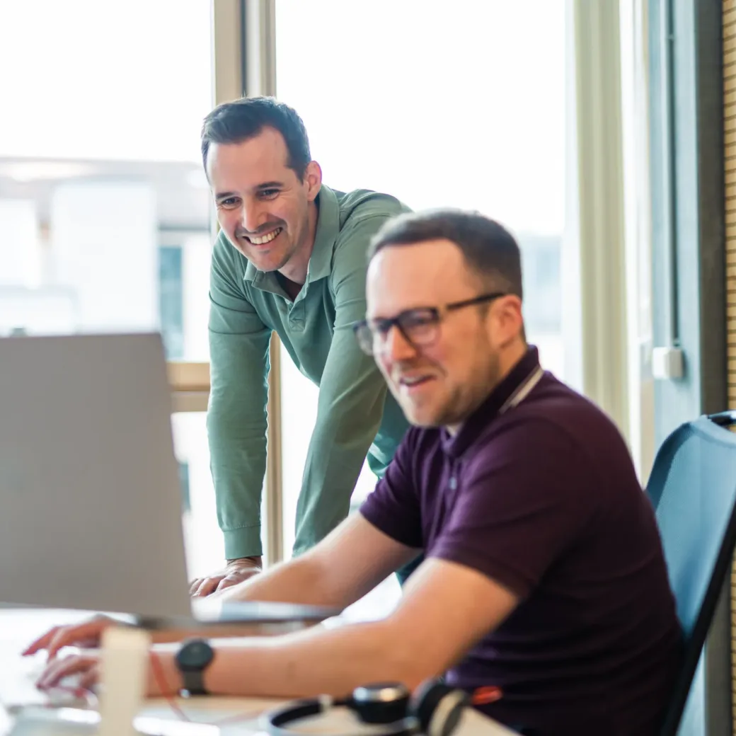 Bild von zwei Kollegen, die an einem Computer-Bildschirm arbeiten.