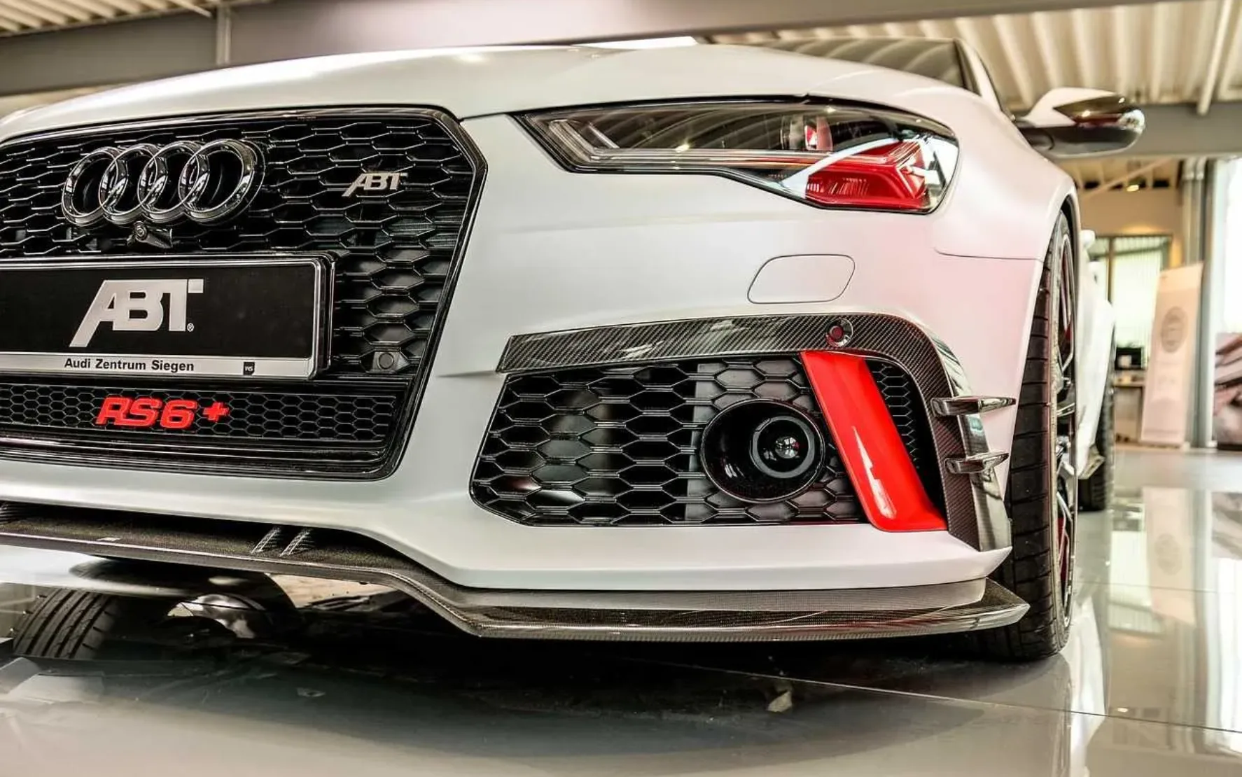 Front eines weißen Audi mit ABT-Logo auf dem Nummernschild