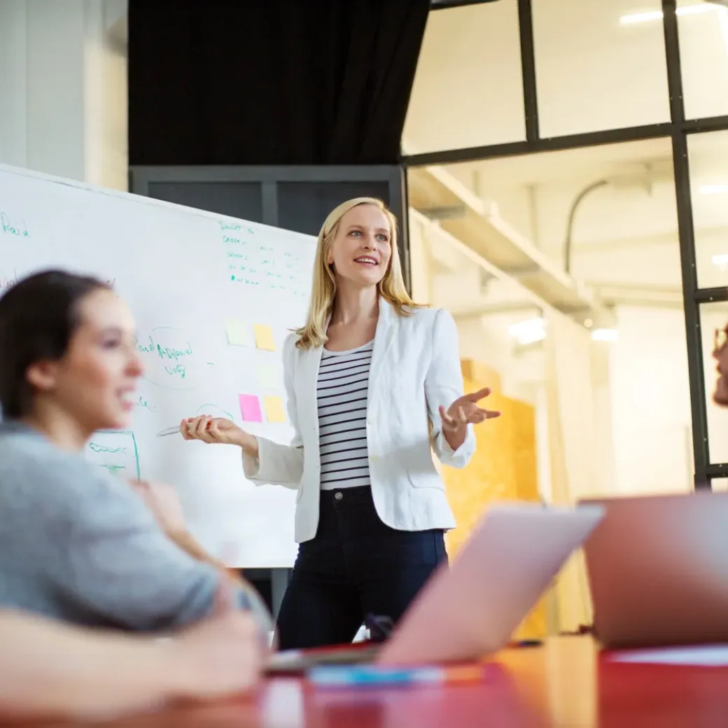 Young businesswoman giving presentation on future plans to her colleagues at office