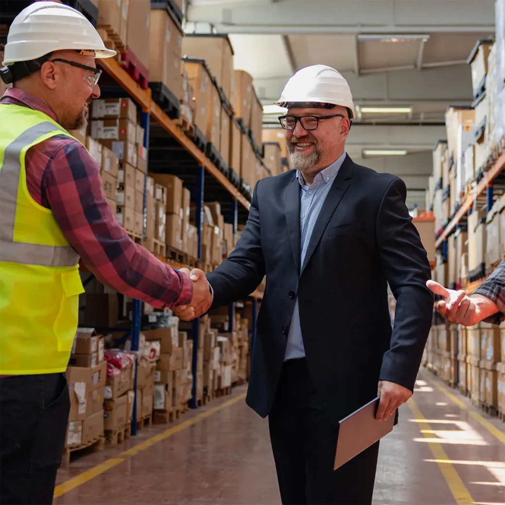 Efficient Collaboration in an Industrial Factory Warehouse: Businessman Engaging with Worker and Engineer, Exchanging Handshake