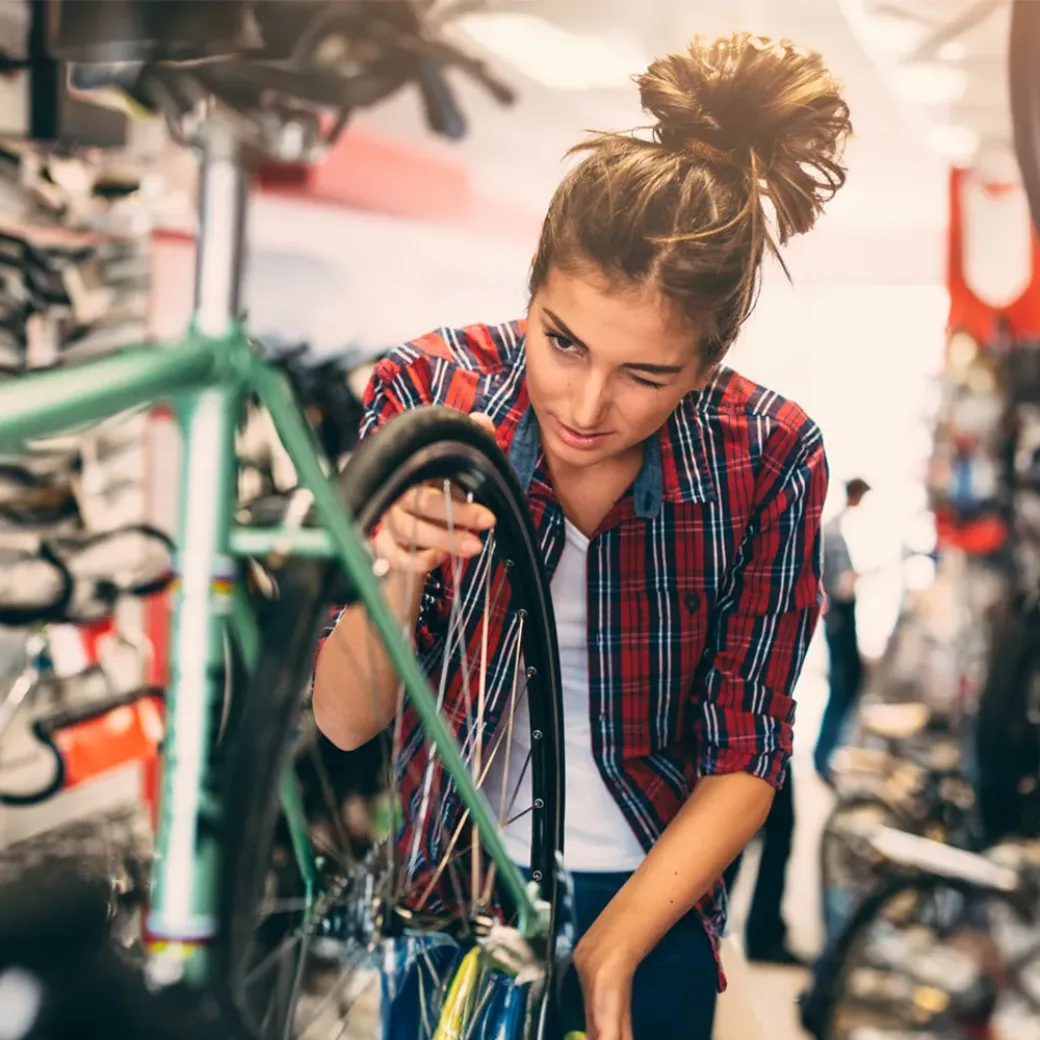 Female bicycle mechanic focusing on a detail while working on a customer's bicycle
