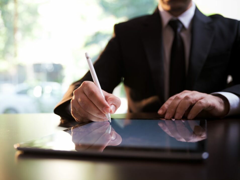 Homem com um fato vestido a escrever num tablet com uma caneta, Consolidação SAP