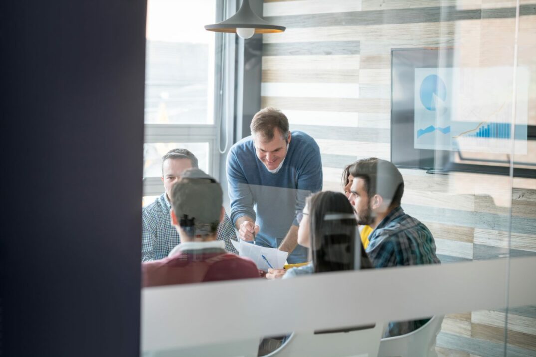 Imagem de um grupo de pessoas sentadas numa sala de reunião, Consolidação SAP
