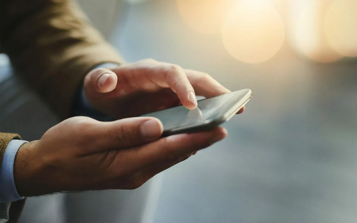 Person, die auf ein Handy tippt | Erfolg im Handel dank Omnichannel Integration