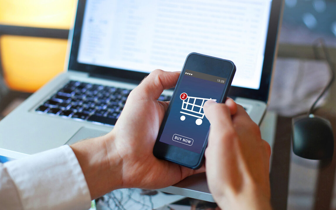 Person, die auf ein Smartphone schaut, auf dem ein Warenkorb mit "Buy Now" abgebildet ist | Skalierbare SAP Onlinehandel Plattform für Wachstum im E-Commerce cs4Commerce