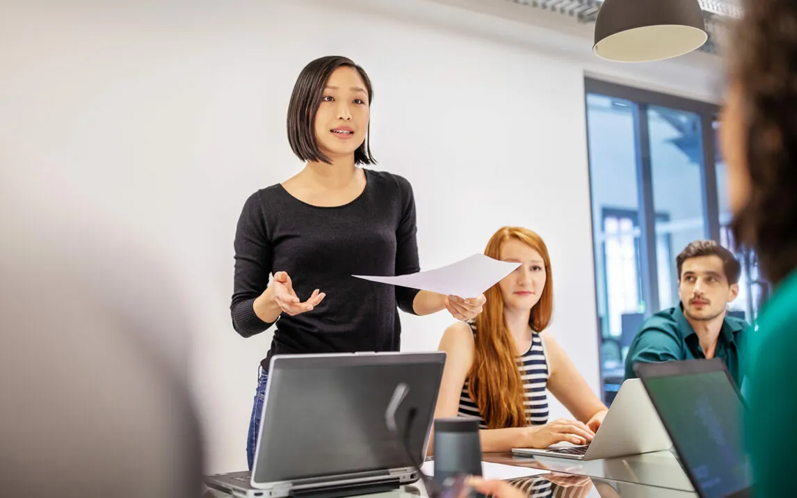 Image of woman talking to people | PlastiVation Plans and Designs Product Lifecycle Management (PLM) With valantic’s Help