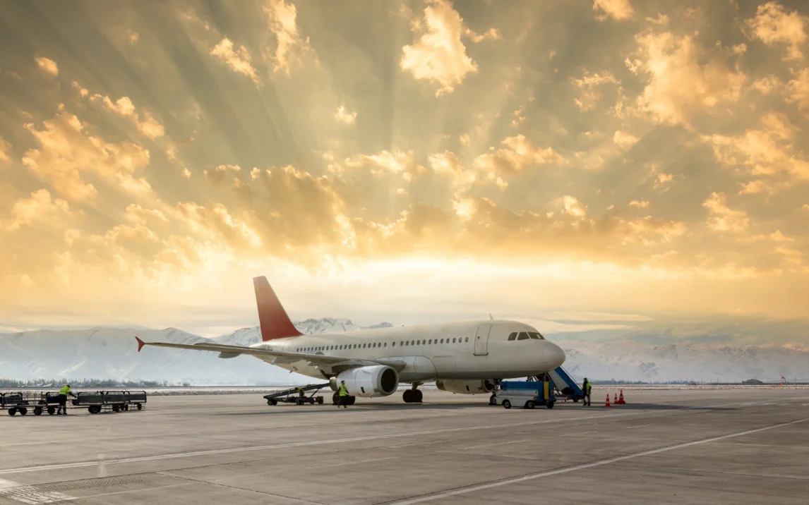 Flugzeug auf einem Rollfeld, im Hintergrund Berge