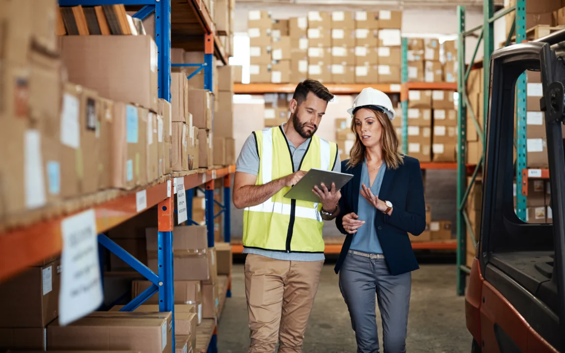 Kollegen im Gespräch, im Hintergrund Lagerregale