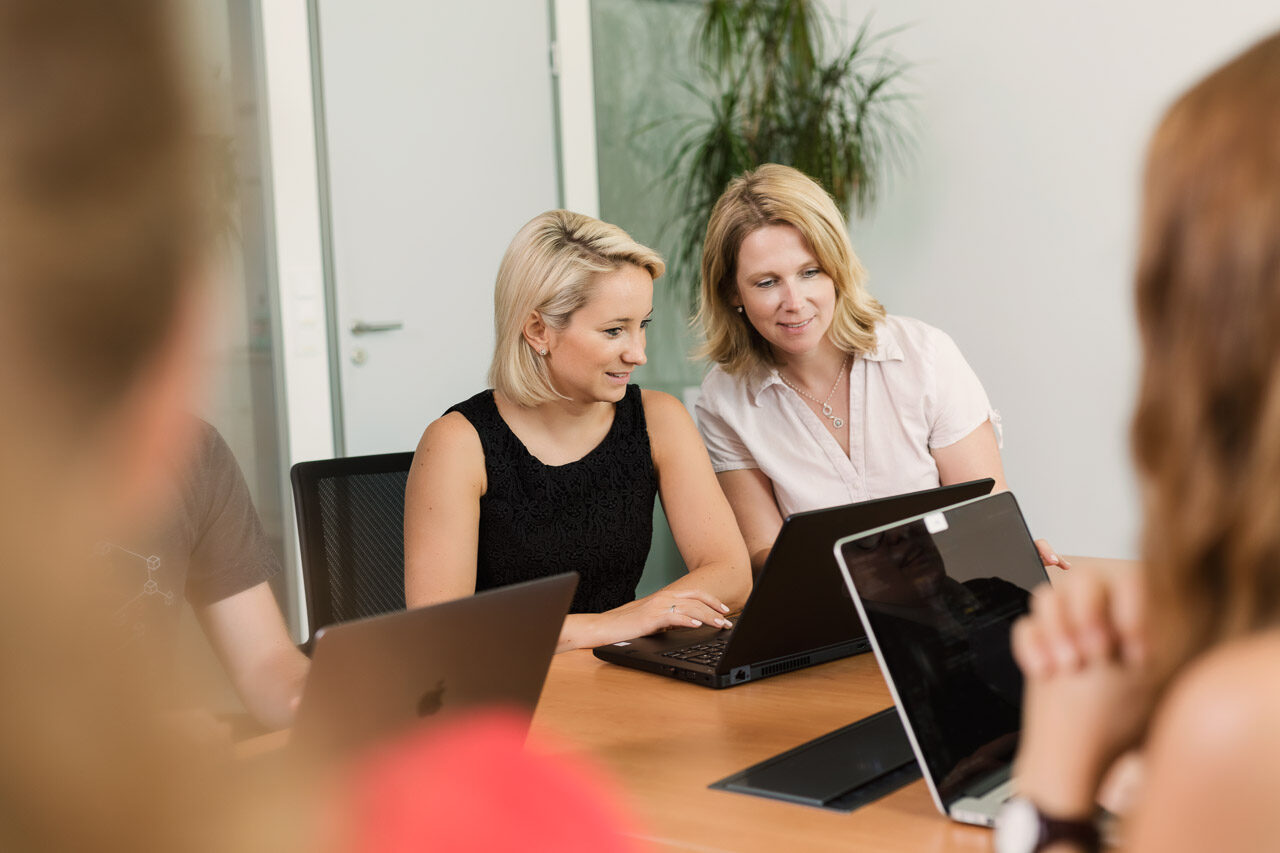 Two valantic employees on a laptop during A/B testing with Optimizely and Agentic AI