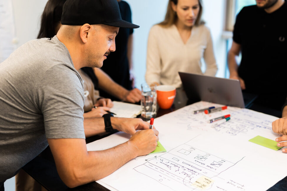 valantic Mitarbeiter*innen schreiben etwas auf ein Plakat