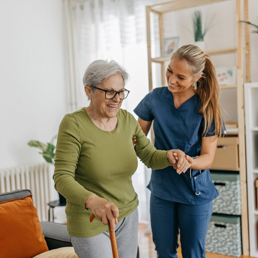 Picture of a female caregiver assisting an elderly woman at home