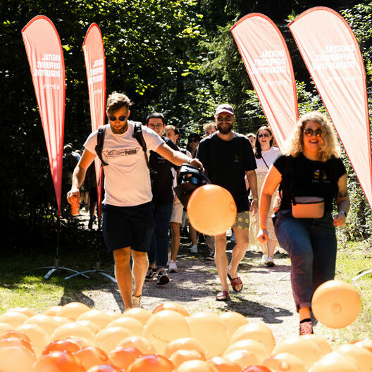 Employees walk over orange balloons