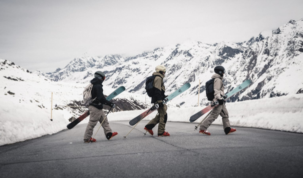 Drei Männer mit Ski, die über eine Straße gehen - Rossignol