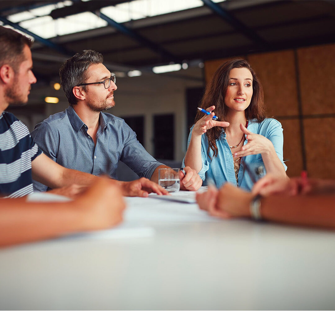 Aufnahme einer Gruppe von Kollegen, die in einem Großraumbüro eine Besprechung abhalten