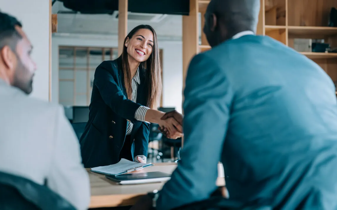 Business people shaking hands in the office. Group of business persons in business meeting. Three entrepreneurs on meeting in board room.