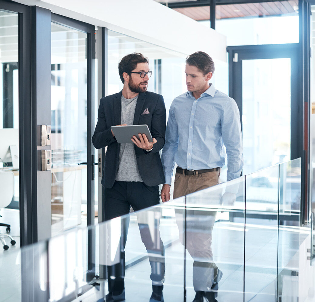 Shot of two businessmen using a digital tablet together in an office