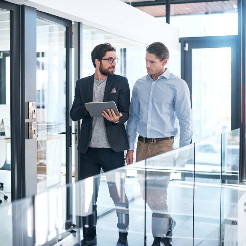 Shot of two businessmen using a digital tablet together in an office