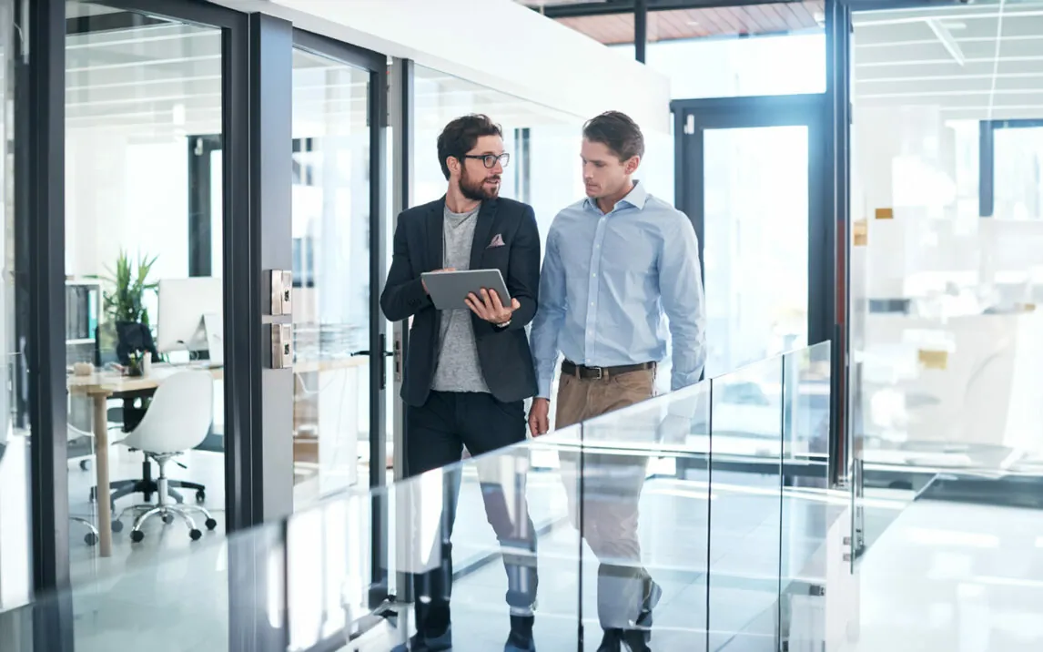 Shot of two businessmen using a digital tablet together in an office