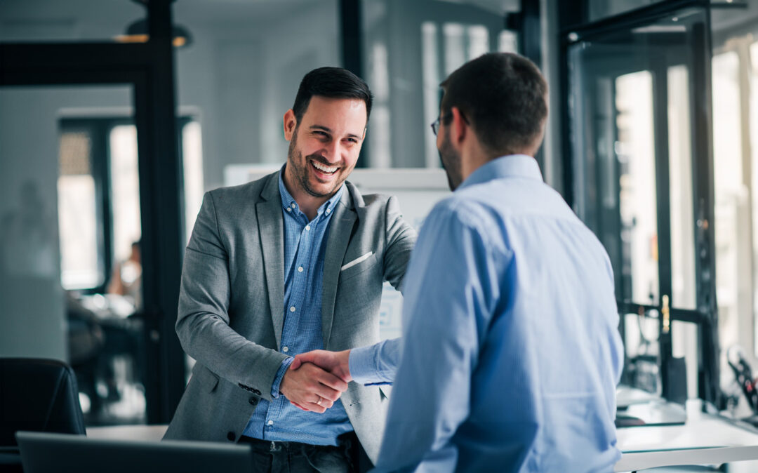 Portrait of cheerful young manager handshake with employee.