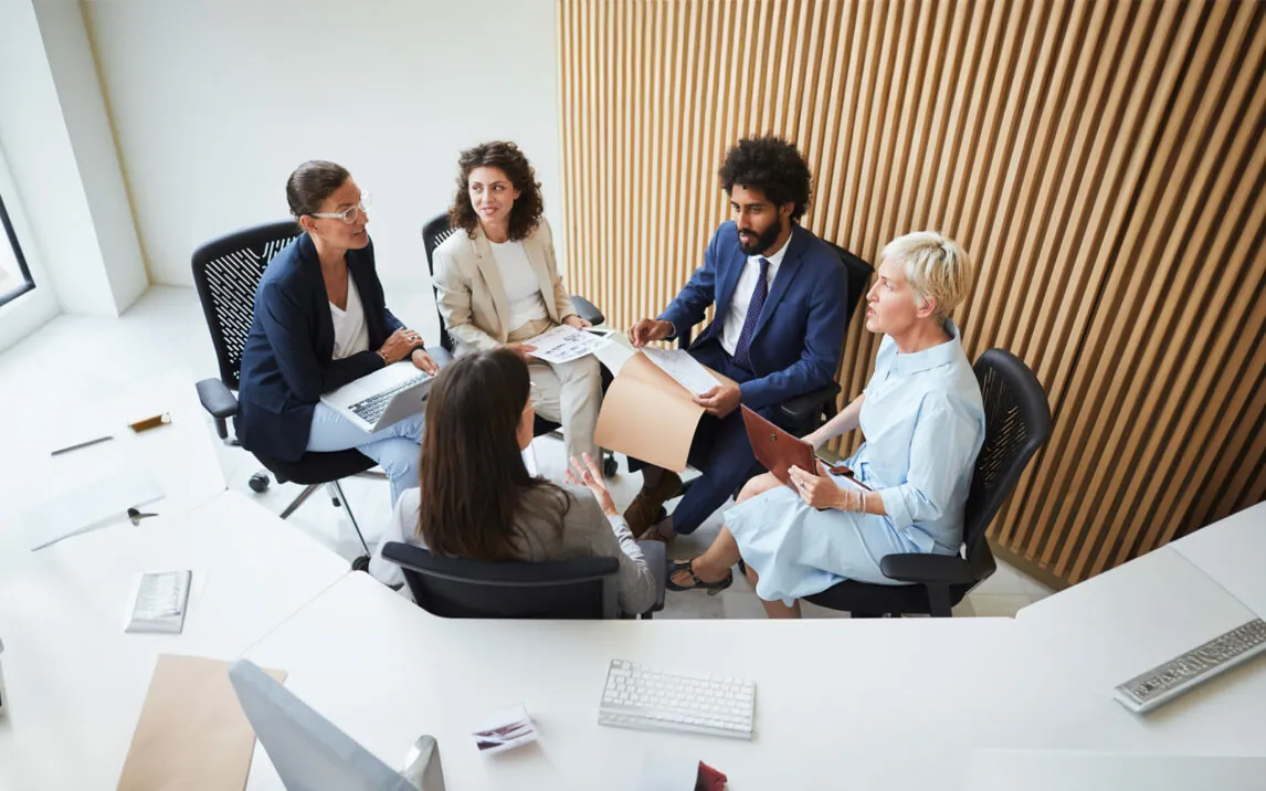 Dynamic colleagues discuss issues in a modern office and conference room.