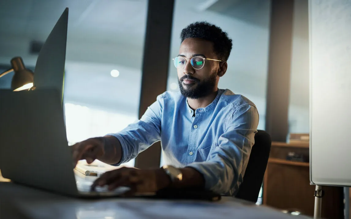 Businessman working on a laptop in an office at night