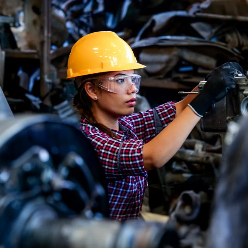 Young Engineer woman working with machine in factory.