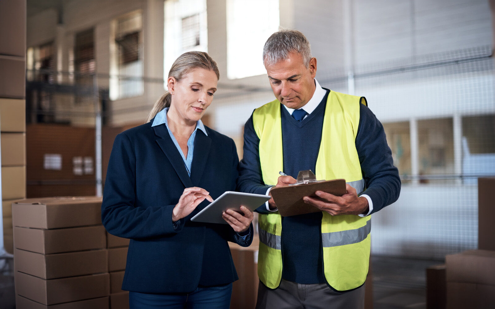 Shot of two factory managers working together in a warehouse