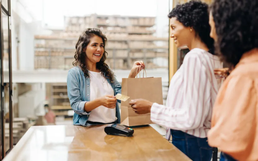 Cheerful young woman smiling happily while shopping from a local female-owned small business.