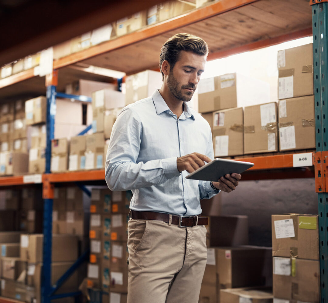 Shot of a young man using a digital tablet while working in a warehouse